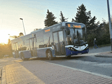 a blue and white bus with the number 116 on it