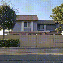 a house with a fence in front of it and a tree