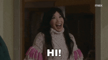 a woman in a sweater is laughing and saying hi .