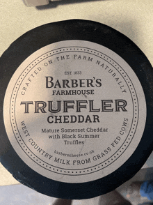 a bottle of barber 's farmhouse truffler cheddar sits on a table
