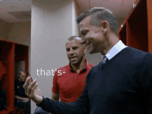 two men in a locker room with the words that 's on the wall behind them