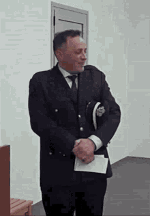 a man in a suit and tie is standing in front of a door .