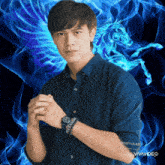a young man in a blue shirt is standing in front of a blue background
