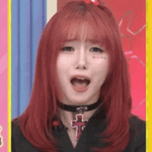 a woman with red hair and a choker with a cross on it .