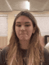 a girl with long hair is making a funny face