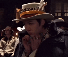 a man wearing a cowboy hat is talking on a phone