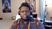 a man in a plaid shirt is wearing headphones and a microphone