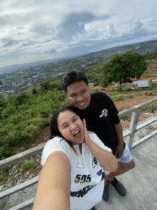 a man and a woman are posing for a picture and the woman is wearing a shirt that says 505 on it