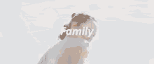 a woman is holding a little girl in her arms and the word family is on the screen .