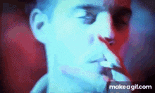 a close up of a man smoking a cigarette in a blurry photo .