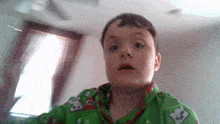 a young boy is wearing a green shirt with a minecraft logo on the front