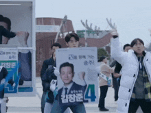 a man is holding a sign that says 4