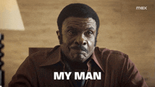 a man sitting at a desk with the word my man written on his face