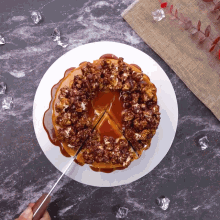 a person is cutting a cake with caramel and popcorn