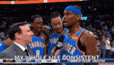 a group of basketball players are standing next to each other on a court .