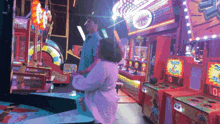 a man and a woman are playing a game in an amusement park with a sign that says 25000 on it