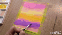 a person is painting with a brush on a piece of paper that says made in animotica on the bottom