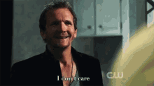 a man is smiling and saying i don 't care in a kitchen .