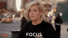 a woman in a black top says focus in front of a netflix logo