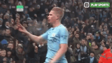 a soccer player is celebrating a goal in front of a crowd at a stadium .