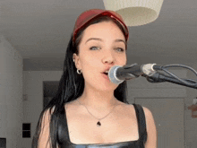 a woman singing into a microphone with a red headband on