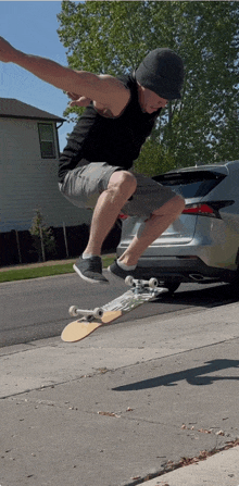 a man is doing a trick on a skateboard in front of a silver suv