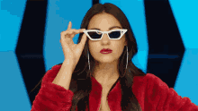 a woman wearing sunglasses and a red jacket