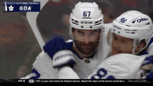 a hockey player with the number 67 on his helmet hugs another player