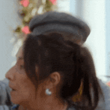 a close up of a woman 's face with a ponytail and earrings