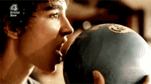 a young man is holding a bowling ball with a 4 brand new logo on it