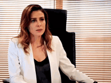a woman in a white jacket is sitting in a chair