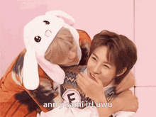 a man wearing a bunny hat is hugging another man who is wearing a bunny hat .