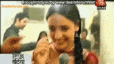 a woman is smiling and talking into a microphone on a screen that says desitvforum.net