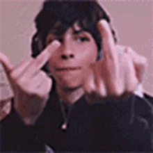 a young man with headphones is giving the middle finger