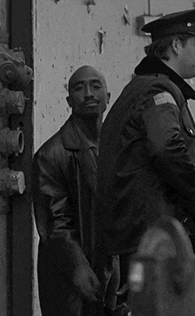 a black and white photo of a man in a leather jacket and a police officer