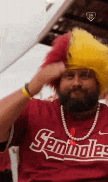 a man with a beard is wearing a seminoles shirt and a yellow wig