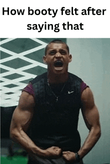 a man is standing in a gym with his arms in the air and screaming .
