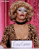 a woman in a leopard print top has a sign that says ellen greene