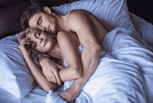 a man and a woman are sleeping together in a bed