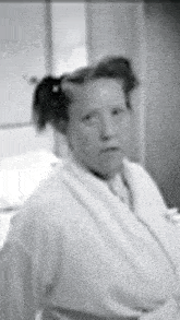 a black and white photo of a woman wearing a white robe and tie .