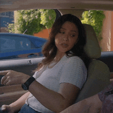 a woman is sitting in the back seat of a car looking at her watch
