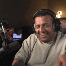a man wearing headphones is smiling and looking at the camera