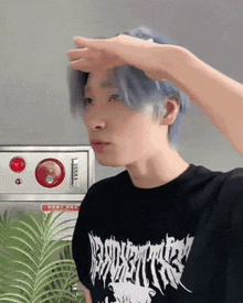 a man with blue hair is wearing a black shirt that says " silence " on it