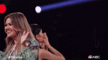 two women are clapping in front of a nbc sign