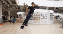 a man is jumping in the air in front of a store