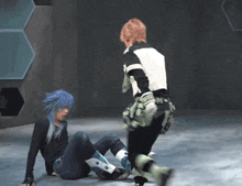 a person with blue hair is laying on the floor next to another person with green pants