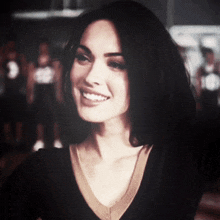 a woman wearing a black shirt with the number 10 on it smiles for the camera