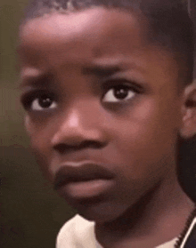 a young boy with a serious look on his face .