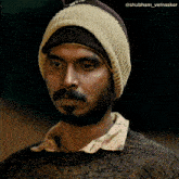 a man with a beard wearing a beanie and a sweater with the name shubhham_velnaskar on the bottom