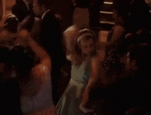 a group of people are dancing together in a dark room .